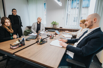 A professional team collaborates during a business meeting, discussing ideas and strategies. The setting reflects teamwork, cooperation, and productivity in a contemporary office environment.