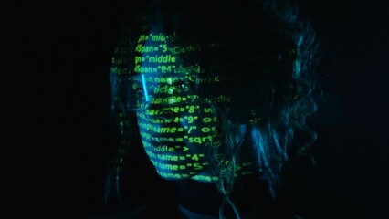 Portrait of a woman with green digital code projection on her face.