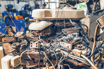 Making socks on knitting machine. Threads, parts, socks production. Thread dust. Textile industry.