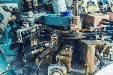 Part of sock knitting machine in operation. Dust from threads. Equipment in textile production.