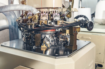 Part of machine with exhaust pipe on industrial knitting machine. Mechanisms of knitting factory.
