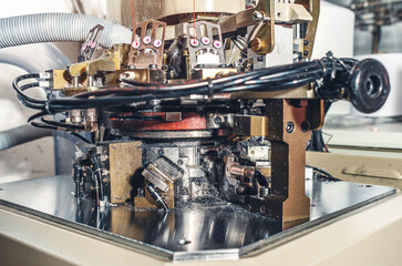 Part of machine with exhaust pipe on industrial knitting machine. Mechanisms of knitting factory.