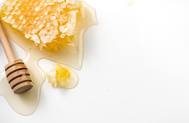 Honeycomb, honey dripping, pouring from wooden honey dipper spoon, on white background, border design, close-up. Honey comb, Healthy organic liquid honey spill. Flat lay, top view. Bees wax. 