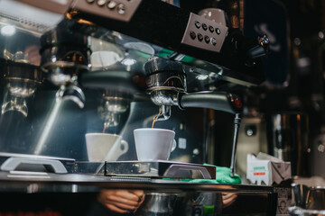 Close-up of an espresso machine brewing coffee into a white cup in a modern cafe.