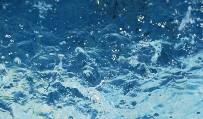 Clear blue water splash with bubbles summer background