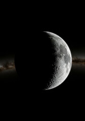 Fototapeta premium Crescent moon in deep space with a detailed texture, a detailed view of the lunar surface. Celestial body in cosmic environment showing craters and valleys.