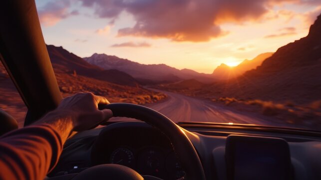 Hand holding car steering wheel on mountain road trip