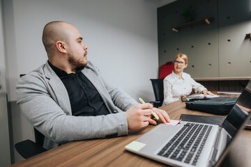 Two colleagues in a modern office setting collaboratively discussing and analyzing work strategies...