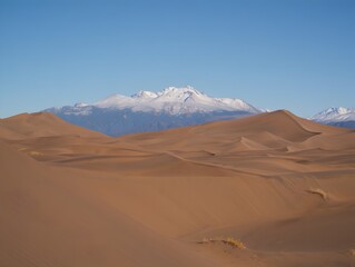 Naklejka premium Explore desert landscape with sand dunes and snow capped mountains scenic view travel