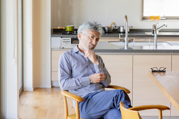 リビングダイニングでくつろぐシニア男性