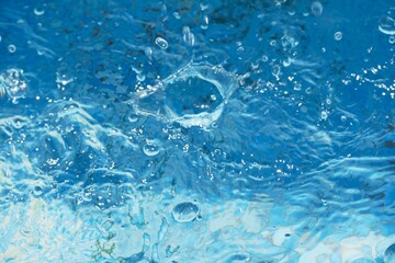Clear blue water splash with bubbles summer background