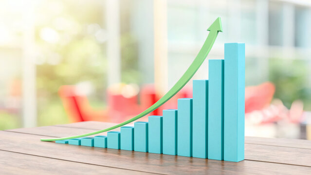 A 3D blue bar chart on a wooden table shows continuous growth with a green upward arrow, set against a bright, blurred background.