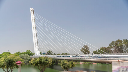 Alamillo Bridge with tall pylon and steel cables crossing over Guadalquivir River timelapse...