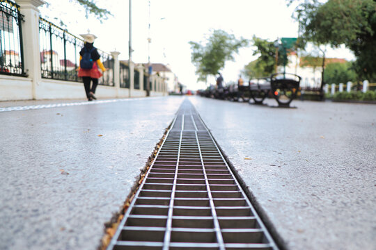 Urban Street with Grated Drain and Pedestrian, Focused on Perspective
