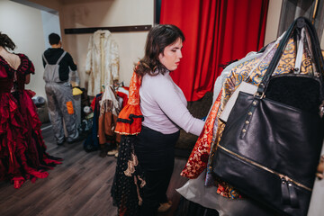 Interior space showing actors arranging theatrical outfits backstage, emphasizing the artistic...