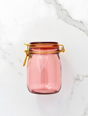 Stock photo of pink glass jar with gold wire latch on white marble background studio shot
