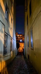 Narrow cobblestone alleyway glows with nocturnal whispers, capturing urban solitude, mystic shadowplay, and echoes of Bonfire Night revelry