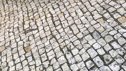 Sunlit cobblestones echo history's whispers, enchanting pavement texture for urban exploration and...
