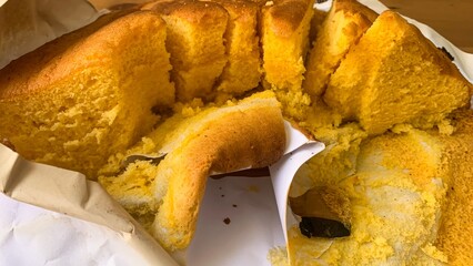 Golden cornbread breaks luxuriously into flaky shards, embodying rustic autumnal harvest, American...