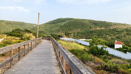 Serpentine boardwalk meanders through verdant hills, whispering tales of Iberian Festas and...