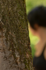 This image features a detailed closeup view of a tree trunk where you can also see a person in the...