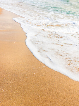 nature with sea foam at the beach. background with wave on the sand. summer vacation at the seaside