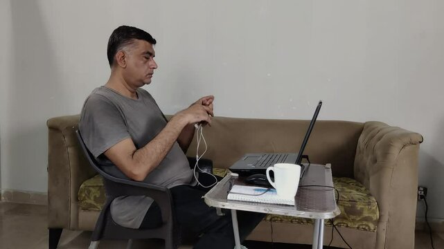 Remote Worker Removes Earphones After Virtual Call and Sets Them Down on Sofa Gently