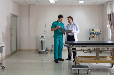 Two healthcare worker in scrub review patient information in a bright, well-equipped hospital room....