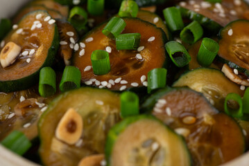 Cucumber salad with sesame seeds, green onion, soy sauce and garlic, closeup. Korean food.