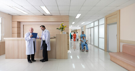 Two doctor in white coat review paperwork at a reception area while patient and nurse move through...