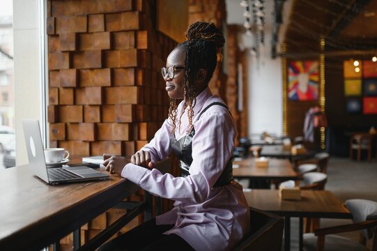 African woman with laptop in cafe