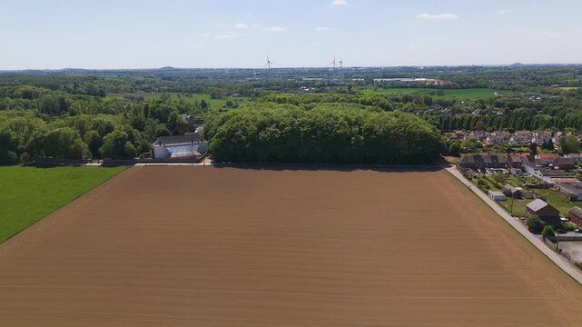 moves empty fields green trees seneffe town visible right distant windmills add to rural charm landscape natural forward aerial drone belgium scenic 