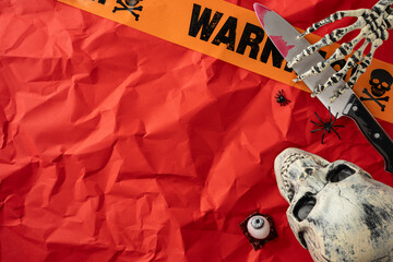 Creepy Halloween arrangement featuring a skull, warning tape, and spooky decorations in a red...