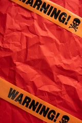 Caution tape over a vertical vibrant red background symbolizing warning and risk in a striking...