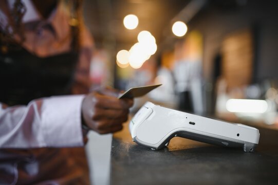 female customer holding credit card near nfc technology on counter