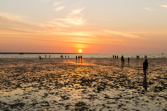 People like to walk out on the tidal flats in the colourful sunset at Menindee Beach