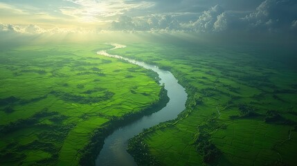 Lush green fields meet a winding river under a bright sky.