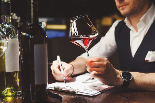 Sommelier studies assortment of alcoholic drinks of restaurant.