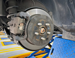 A car's brake assembly is under inspection at an auto repair facility. The technician assesses the...