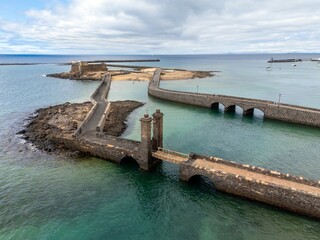 Canary Islands, An aerial view of Arrecife and two bridges, Lanzarote, would showcase a vibrant coastal city built on volcanic landscapes.