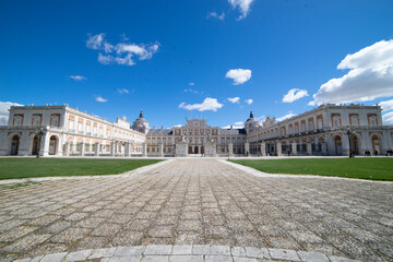 Historical architecture of Aranjuez showcases royal palace and gardens under a bright blue sky in Spain's cultural landscape