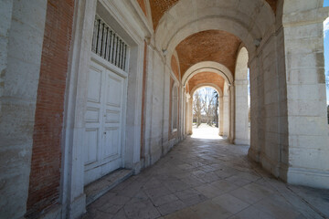 Exploring the historic passageway of the Royal Palace in Aranjuez, Spain, revealing architectural beauty and tranquility