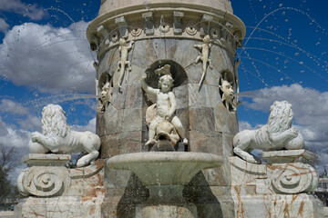 Fountain featuring sculptures of lions and a cherub in Aranjuez, Spain during a sunny day
