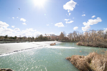 Beautiful landscape of Aranjuez with flowing water and historic buildings under a clear blue sky