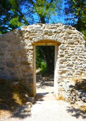 Ancient stone gate entrance in the forest with green trees