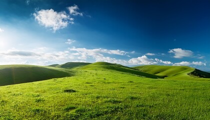 Obraz premium grassy landscape with small hills shining blu sky with cloud
