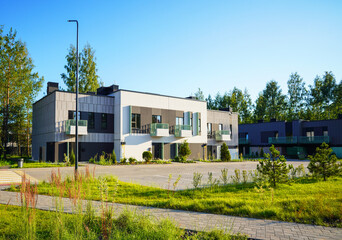 Modern townhouse in suburban area. New apartment building in sustainable enviroment. Two-story contemporary townhouse in suburb. New Modern Townhome in Cityscape. Residential neighborhood Street.