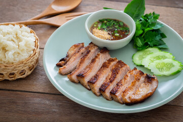 Grilled pork neck and thai spicy dipping sauce on plate served with sticky rice