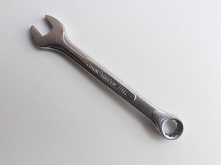 A ring spanner, also known as a combination wrench, isolated on a white background.