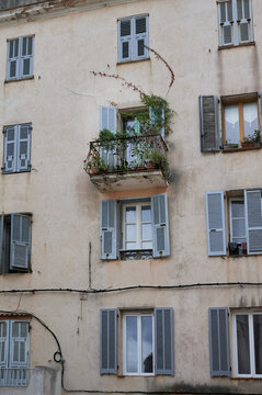 facade of an old house with a balcony an the shutters are opem